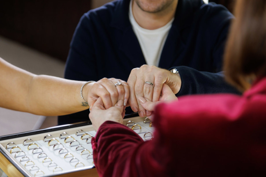 Couple try on wedding rings with the help of James Porter & Son employee